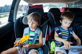 Two Boy In Car Seats Traveling In Car