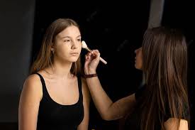 makeup artist applies foundation on