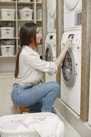 Free Photo | Woman using washing machine doing the laundry. young woman ready to wash clothes. interior, washing process concept