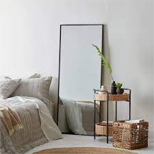 a mirror facing the bed