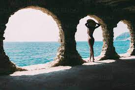Nackte schwarze Frau, die den Blick aufs Meer genießt, lizenzfreies  Stockfoto