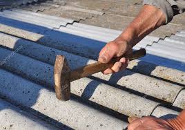 roofer installs asbestos roof shingles