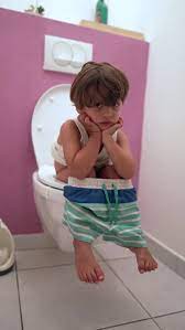 Child Seated On Toilet In Vertical