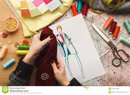 Female Fashion Designer Working With Fabric Sample And Drawn