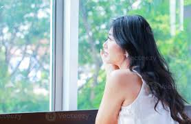 retrato de uma linda mulher asiática sentada alegremente perto da janela em  fundo natural 2045469 Foto de stock no Vecteezy