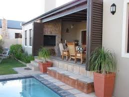 The patio area located at ground level of this home has everything you could ever need for comfort. Pool Landscaping Ideas To Add An Oasis Of Tranquility And Enhance Your Experience Around The Pool Pool Landscaping Patio Patio Ideas South Africa