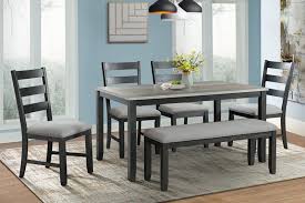 A small dining space with a wooden dining table paired with black chairs over concrete flooring. Martin Dining Table 4 Chairs Bench In Gray Mor Furniture