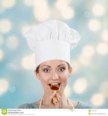 Closeup portrait of happy woman in chef&#39;s hat tasting sauce with a wooden spoon on abstract background. MR: YES; PR: NO - happy-woman-chef-s-hat-tasting-sauce-closeup-portrait-wooden-spoon-abstract-background-31293736