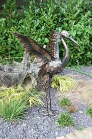 small bronze crane with wings up garden