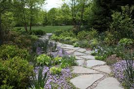 Adding the border of white rocks along with the pink pavers creates a remarkable image. What To Know About Installing A Walkway Of Pavers And Pebbles