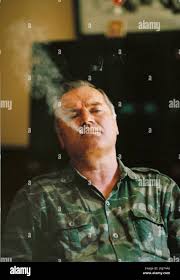 Ratko Mladic, Supreme Commander of the Serbian forces in Bosnia during the  war, exhales some jcigarrete smoke during an interview in Han Pijesak,  Bosnia Stock Photo - Alamy