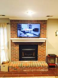 tv mounted on a brick fireplace in