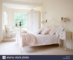 We love the white iron sleigh bed and its charming, feminine design which surely stands out gorgeously in this rustic chic bedroom. Pale Pink Silk Quilt White Wrought Iron Bed Cream Country Bedroom Carpet House N Decor