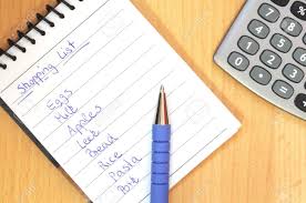 Shopping List With Pen And Calculator On Brown Desk Stock Photo