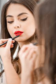 makeup artist applies lips pencil