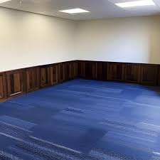 blue carpet and wooden paneled walls