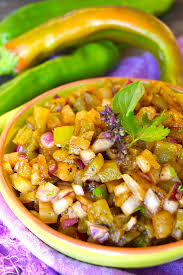roasted double hatch chile pineapple salsa in green ceramic dish with cilantro sprig and purple basil