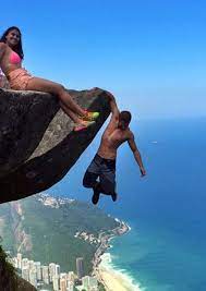 Leonardo Edson Pereira and Victoria Medeiros hanging off an almost 3000ft  drop straight into the ocean with no support - Mirror Online