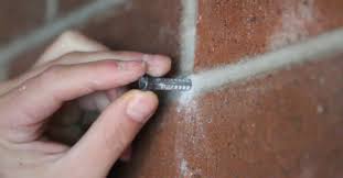 Devices called brick clips or brick hangers allow people to hang pictures, mirrors and other objects on walls without drilling into the brick. How To Drill Into A Brick Wall
