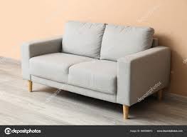 grey couch beige wall room stock photo