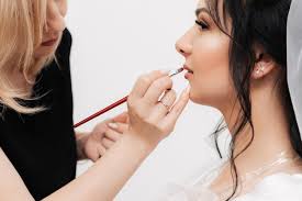 makeup artist applies lip gloss
