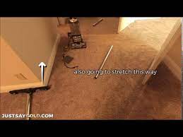 stretching carpet in a room with