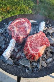 steaks on the coals over the fire cooking