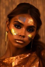 a woman with gold makeup and a gold face