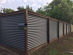 Rather than constructing the entire fence one board at a time, build the panels then attach them to the fence posts. Corrugated Iron And Hardwood Fence Metal Fence Panels Corrugated Metal Fence Fence Design