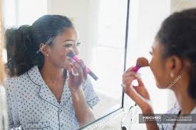 applying makeup in bathroom mirror