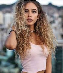 With dark roots, the blonde hue glows even brighter. Curly Long Hair Blonde