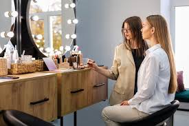 woman and makeup artist looking at mirror