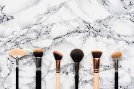 makeup brushes on white marble