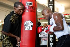 floyd mayweather sr holds a heavy bag for his son floyd jr of the u s during a a workout at the mayweather boxing club in las vegas