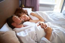 Young Caucasian Man And Woman Lie On Bed
