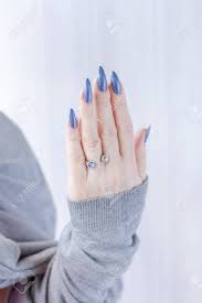 Female Hand With Long Nails And Light Blue Manicure With Bottles Stock Photo Picture And Royalty Free Image Image 155822991