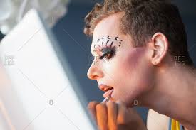 man applying drag queen makeup stock