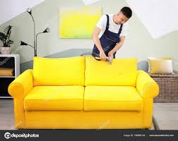 dry cleaning worker removing dirt sofa