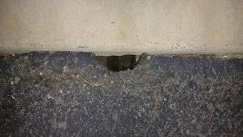 hole in asphalt by garage floor the