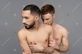 上半身裸のパートナーの肩に後ろからキスする若い白人男性のクローズアップ のフォト