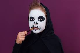 child with halloween makeup in skeleton