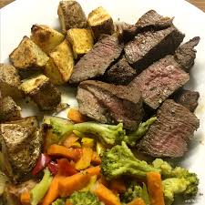 venison steak dinner with browned potato chunks and a melange of vegetables prising of broccoli