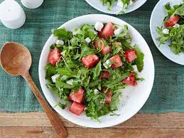 In a large bowl, stir together the cherry tomatoes, 1/2 cup olive oil, garlic, basil, red pepper flake, 1 teaspoon of salt, and pepper. Arugula Watermelon And Feta Salad Recipe Ina Garten Food Network
