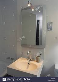 Details Of A Modern Bathroom Sink Infront Of A Mirror With A Small Shaving Light Above Stock Photo Alamy