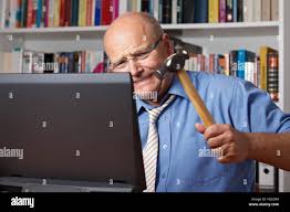 Very angry old man with shirt and tie hitting his computer with a hammer,  frustration, stress, crisis Stock Photo - Alamy