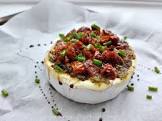 brie topped with pesto and sun dried tomatoes