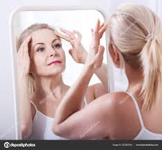 middle aged woman looking at wrinkles