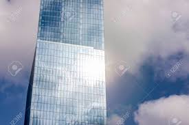 Glass Corporate Blue Skyscraper With Sun Reflection In Windows