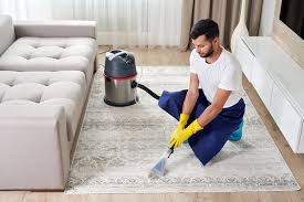 man cleaning carpet in the living room