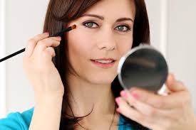woman applying makeup with brush